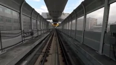 4k, modern sürücüsüz yolculuğun gerçek hızına doğru hızlandırılmış hızlandırma. Şehir boyunca uzanan tünel boyunca uzanan yüksek raylı metro sistemi. POV otomatik tren görünümü - Dan penceresinden