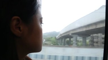 Trende oturan ve pencereden dışarı bakan üzgün genç bir kadının yakın plan fotoğrafı.