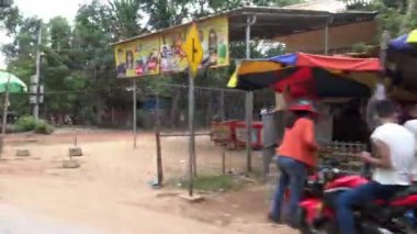 Siem Reap, Kamboçya-16 Nisan 2018: 4K, Kamboçya 'nın yeni yılında, bir tuk tuk' ta turistin POV 'undan çıkan ünlü su tabancası. Gençler ateş ediyor ve su fırlatıyor.