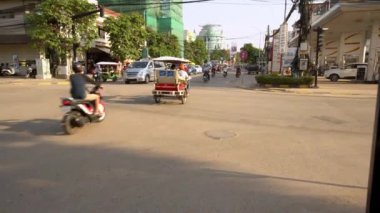 Siem Reap, Kamboçya-20 Nisan 2018: 4k, yeşil bir trafik ışığı görünüyor. Tuk Tuk, motosikletler ve bisikletler Kamboçya yolunu paylaşıyor.