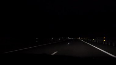 4K, gece İspanya 'da otoyolda araba sürerken görüntüsü. Karanlık bir akşamda boş bir yolda sür. Otobanda bir araba sürüyor. Yeni yolda beyaz çizgili asfalt.