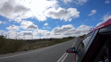 4K, İspanya 'nın yel değirmenleriyle güzel kırsallarda araba sürüyor. Mavi gökyüzüyle aydınlık bir yaz gününde yola çıkmak. Alanın İspanyol manzarası. -Dan.