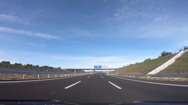 4K, İspanya 'nın güneyindeki Seville illerinde otoyolda giden araç görüntüsü. Otobanda bir araba sürüyor. Yeni yolda beyaz çizgili asfalt.