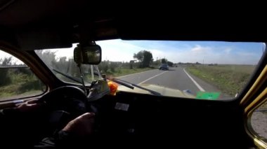 Sevilla, İspanya-17 Aralık 2018: 4K, Endülüs 'ün kırsal kesişiminde küçük bir kasaba kavşağında eski bir arabanın POV' u. Klasik araba genelde tekerlekli şemsiye ya da iki buharlı at çağırır.