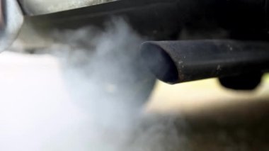 4K, araba egzoz borusundan çıkan yakın çekim dumanı çok güçlü beyaz dumandan. Yoldaki araçtan zehirli karbon monoksit, hava kirliliği konsepti. Trafikte duman emisyonları