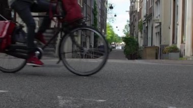 Amsterdam, Hollanda-13 Mayıs 2019: Amsterdam bisikletçisinin sokaklarda ağır çekimde seyahat etmesi. Bisiklet ana ulaşım biçimidir. Bisiklet süren insanlar. Şehirde bisiklete bin. -Dan.