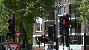 Amsterdam, Hollanda-13 Mayıs 2019: Avrupa yaya geçidi tabelası. Kırmızı renkli trafik ışıkları ve arkadan geçen tramvaylar. Hollanda caddesinde kesişen yol. Avrupa şehir merkezi Dan