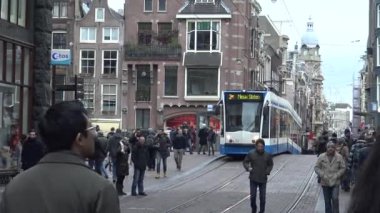 Amsterdam, Hollanda-06 Aralık 2015: 4k, Amsterdam, Hollanda-Dan 'de karşıdan karşıya geçen tramvaylar ve turistler