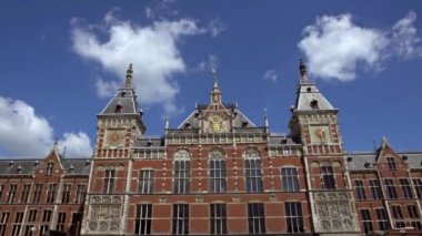 4K, tarihi Amsterdam Centraal binası, merkezde mavi gökyüzü olan ana tren istasyonunun dış görünüşü. Hollanda. - Dan.