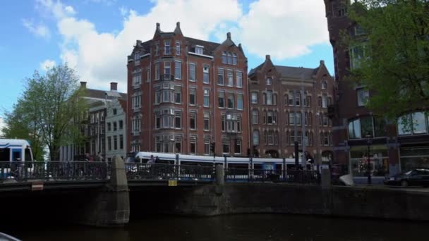 アムステルダム オランダ 2019 トラム 通りを横断する観光客 トラムはオランダの旧市街の中心部を通過します 周りのアパートの建物 公共交通機関の概念 — ストック動画