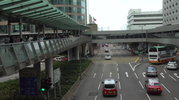 Hongkong 2017年4月4日 4K歩道橋の横断歩道を歩く人々の混雑 車やバスで香港で忙しい生活は一日で道路を通過します 歩行者用橋段 — ストック動画