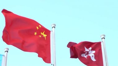 Çin Cumhuriyeti ve Hong Kong 'un yavaş çekim bayrakları mavi gökyüzü Dan ile güzel bir günde rüzgarda sallanıyor.