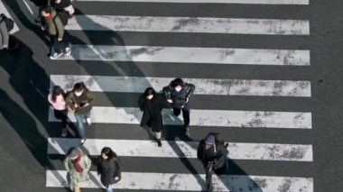 Tokyo, Japonya-02 Şubat 2020: Gün batımının ışığıyla kavşakta kalabalık bir yaya geçidinin manzarası yükseldi. Asyalıların yoğun yaya geçidi görüntüsü. - Dan.