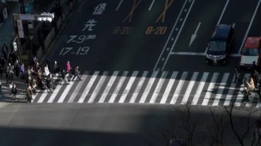 Tokyo, Japonya-02 Şubat 2020: 4K, gün batımının ışığıyla kavşakta kalabalık bir yaya geçidinde görüntüyü yükseltti. Gün ortasında Asya 'da. Metropolitan Şehir-Dan
