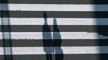Gün batımının ışığıyla kavşakta kalabalık yaya geçidi üzerinde yavaş çekim var. Asyalıların yoğun yaya geçidi görüntüsü. - Dan.