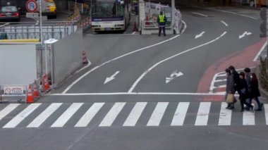 Tokyo, Japonya-04 Şubat 2020 Shibuya kavşağındaki kalabalık yaya geçidinde ağır çekim. Asyalıların kalabalık yaya geçidinde hava görüntüsü. Gün ortasında Asya 'da. Metropolitan Şehir-Dan