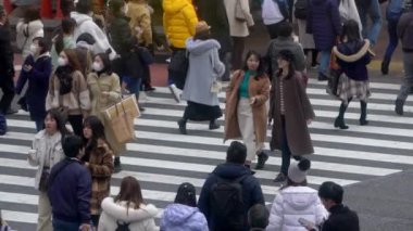 Tokyo, Japonya-04 Şubat 2020 Shibuya kavşağındaki kalabalık yaya geçidinde ağır çekim. Asyalıların kalabalık yaya geçidinde hava görüntüsü. Gün ortasında Asya 'da. Metropolitan Şehir-Dan