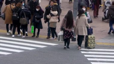 Tokyo, Japonya-04 Şubat 2020: Shibuya 'dan geçen yaya kalabalığının yavaş hareketi. Asyalıların manzarası yükseldi. Yerel halk ve turistler en işlek yol kavşağında yürüyor. Sokak Dan.