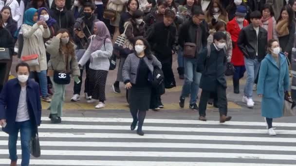 2020年2月 渋谷交差点における感染症対策マスクを着用したアジア人のスローモーション 忙しいスクランブル交差点での歩行者の空中ダン — ストック動画
