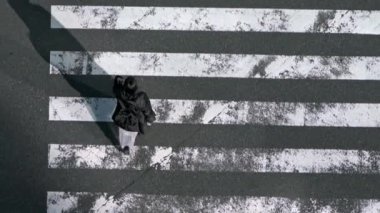 Trafik arabaları ve gün batımı ışıklarıyla yaya geçidi üzerinde hava manzarası. En işlek yol kavşağında yürüyen Asyalıların manzarası yüksekti. - Dan.