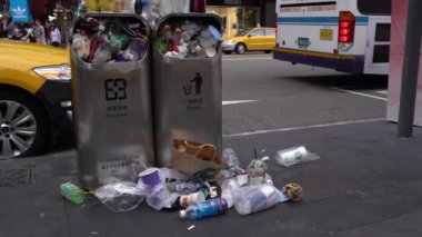 Taipei, Tayvan-13 Ağustos 2017: 4K. Taipei caddesindeki aşırı dolu çöp tenekesinden dökülen çöp. Asyalı bir kadın yolda yürürken çöp kutusuna çöp atıyor. Şişeler, teneke kutular ve diğer çöp kutuları - Dan