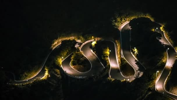 夜には山の中で美しいSカーブの道を運転する高架ビュー車のハイパーラプス 基隆山 夕方になると 森林を介して丘の中腹の道路の空中のタイムラプス 十分旅段 — ストック動画