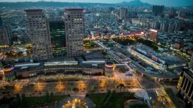 4K Timelapse Havadan Geceye, sokak trafiği ve yayalar. Otobüslerin, arabaların ve Taipei 'deki insanların bulunduğu şehir manzarasının güzel zamanlaması. Şehir simgesi gökdelen Banqiao-Dan
