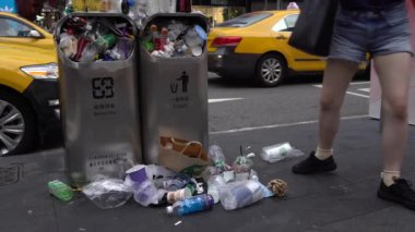 Taipei, Tayvan-13 Ağustos 2017: 4K. Taipei caddesindeki aşırı dolu çöp tenekesinden dökülen çöp. Asyalı bir kadın yolda yürürken çöp kutusuna çöp atıyor. Şişeler, teneke kutular ve diğer çöp kutuları - Dan