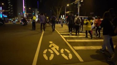 Taipei, Tayvan-29 Mart 2017: 4K Asyalı erkek polis memuru, yaya trafiğini düzenliyor yoğun bir zamanda yolda yürüyor, yanıp sönen bir ışık çubuğu kullanıyor, ıslık çalıyor, Dan kavşağında çalışıyor.