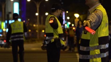 Taipei, Tayvan-29 Mart 2017: Ağır çekim Asyalı erkek polis memuru, yaya trafiğini düzenliyor, yoğun saatlerde yolda yürüyor, yanıp sönen bir ışık çubuğu kullanıyor, ıslık çalıyor
