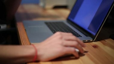 İşadamı elleri dizüstü bilgisayarın klavyesinde daktilo kullanıyor, masada Not Defteri ile çalışıyor.