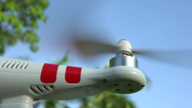 4K Helicopter 'ı güzel bir yaz günü güneşli bir parkta kalkışa hazırlıyor. Mavi gökyüzü arka planına sahip modern bir RC Drone. Kameralı Quadrocopter - Dan