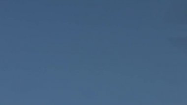 Ağır çekim, modern bir RC Helicopter mavi gökyüzü arka planıyla uçuyor. Kameralı kırmızı ve yeşil ışık kuadrokopteri. Yavaş çekim hızı 120 fps-Dan.