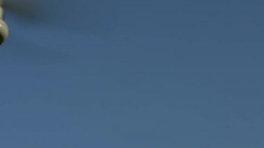 Ağır çekim, modern bir RC Helicopter mavi gökyüzü arka planıyla uçuyor. Kameralı kırmızı ve yeşil ışık kuadrokopteri. Yavaş çekim hızı 120 fps-Dan.