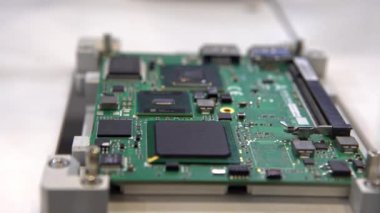 , -26 Nisan 2019: 4K, fabrika makineleri çalışıyor. Mikroçipleri ana karta bağlayan yüzeye monte edilmiş teknoloji. Makro yakın plan. Devre kartı otomatik robotik kolla monte ediliyor. - Dan.
