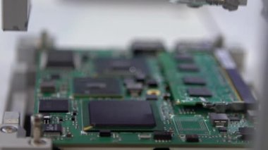 , -26 Nisan 2019: Fabrika makinelerinin Yavaş Hareketi. Mikroçipleri ana karta bağlayan yüzeye monte edilmiş teknoloji. Devre kartı otomatik robotik kol Dan ile monte ediliyor