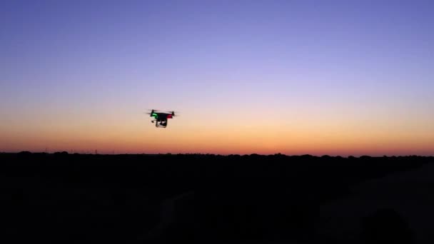 日没の空とフィールド上のデジタルカメラで飛行ドローンクワッドコプターの空中ビュー スペインの田舎の風景 オレンジ色の太陽の下で美しい景色 現代の新技術 — ストック動画