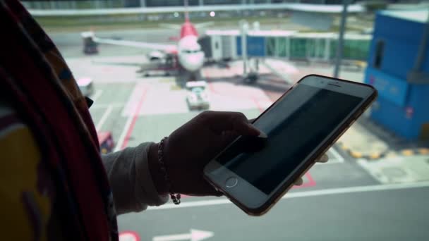 Giovane Donna Possesso Telefono Cellulare Con Sfondo Aereo All Aeroporto — Video Stock