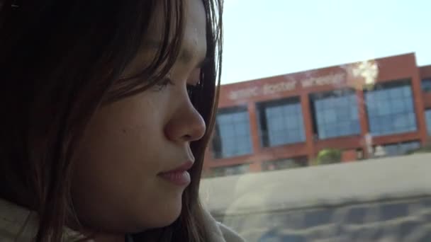 4K中国英语学习网在西班牙 一名亚洲妇女面对一辆正在行驶的公共汽车的窗户附近旅行的特写镜头 — 图库视频影像