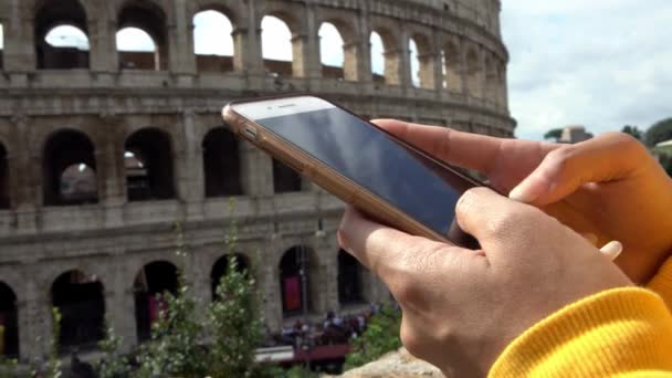 Close Weibliche Hand Halten Und Touchscreen Smartphone Mit Kolosseum Hintergrund — Stockvideo