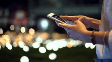 4K, geceleyin Taipei 'de elinde cep telefonu tutan ve daktilo kullanan Asyalı bir turisti çek. Kız akıllı telefonu kontrol et ve internette sörf yap - Dan tatilinde