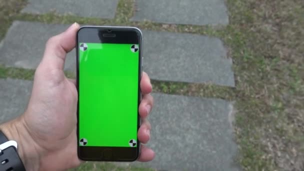 Kaukasische Man Tonen Het Groene Scherm Telefoon Tijdens Het Lopen — Stockvideo