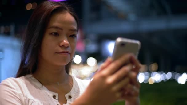 夜に台北で携帯電話を保持し 入力する観光アジアの女性の閉鎖 女の子チェックザスマートフォンとサーフィンでインターネットで休暇 Dan — ストック動画