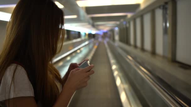 Young Asian Woman Typing Mobile Phone Moving Sidewalk International Airport — Stock Video