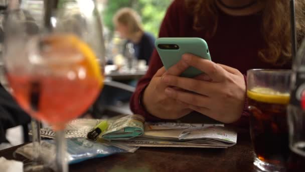 白人女人在酒吧里用智能手机 杯子里放着闪光的开胃酒 意大利餐馆里的触摸屏手机 浏览互联网 检查社交网络 在手机上发短信 — 图库视频影像