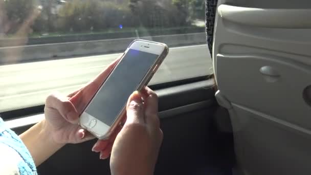 4K若いアジアの女性は タッチスクリーンのスマートフォンデバイスを使用しました インターネットをサーフィンし ソーシャルネットワークをチェック スペイン ダンでのバスに乗って太陽の下で彼女の携帯電話をチェック — ストック動画