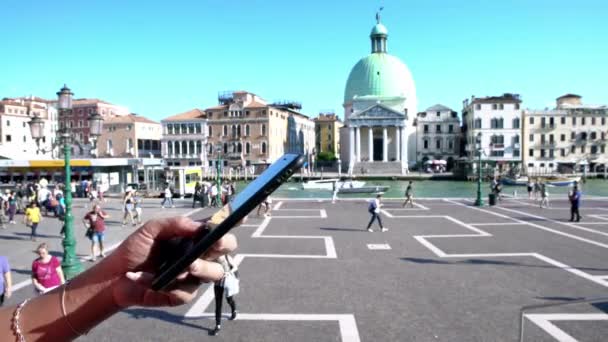 イタリア ヴェネツィア 2018年9月21日 アジアの女性は シメオーネ ピッコロの背景を背景にスマートフォンを路上で使用しています 駅前で携帯電話を持っている女性の手の閉鎖 — ストック動画