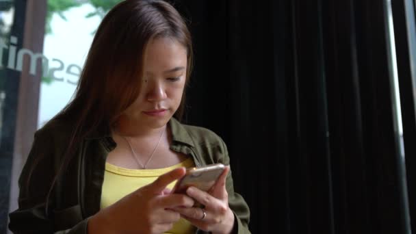 4K亚洲女人在咖啡店用智能手机 触摸屏幕聊天和与人联系 在网上冲浪 查看社交网络 在手机上发短信的好时机 — 图库视频影像