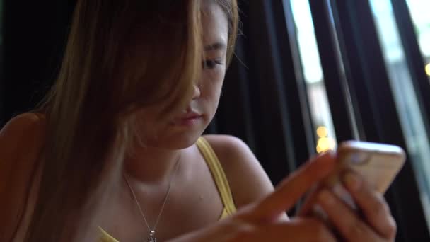 4K亚洲女人在咖啡店用智能手机 触摸屏幕聊天和与人联系 在网上冲浪 查看社交网络 在手机上发短信的好时机 — 图库视频影像