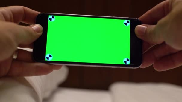 Kaukasische Man Tonen Een Green Screen Telefoon Met Een Bed — Stockvideo